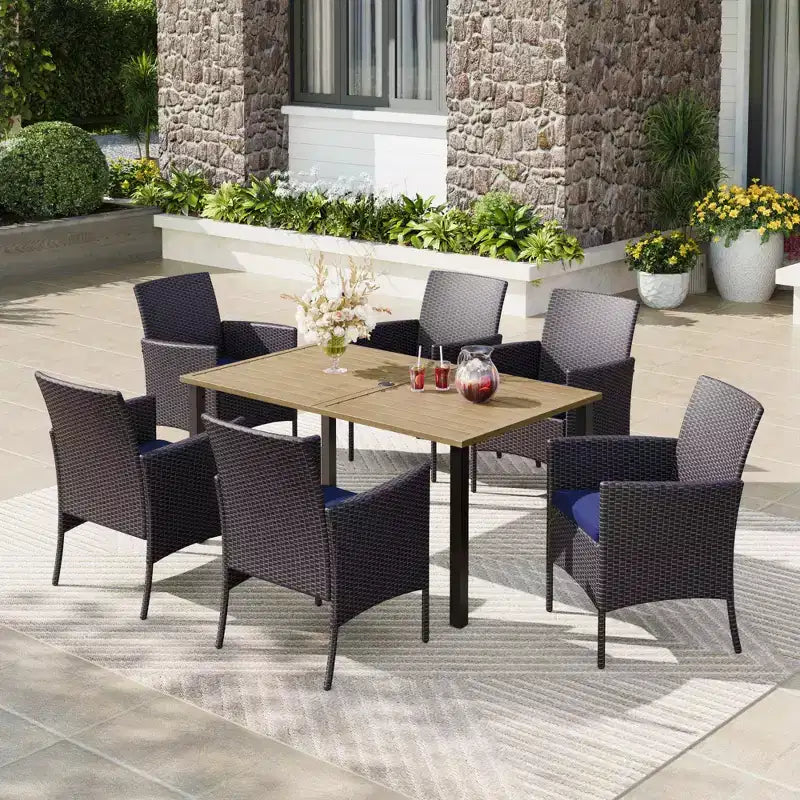 Captiva Designs Set da pranzo 7 pezzi con tavolo in acciaio con ripiano a doghe e foro per ombrellone e sedie in rattan con braccioli imbottiti